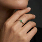 Woman wearing verdant duo bezel diamond and emerald ring in yellow gold