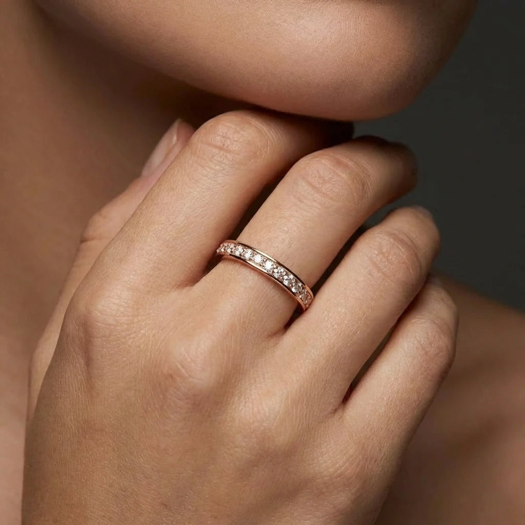 Female model wearing Virel Pavé Diamond Eternity Band in 14K rose gold, close-up editorial portrait shot showing continuous pavé round brilliant diamonds on finger
