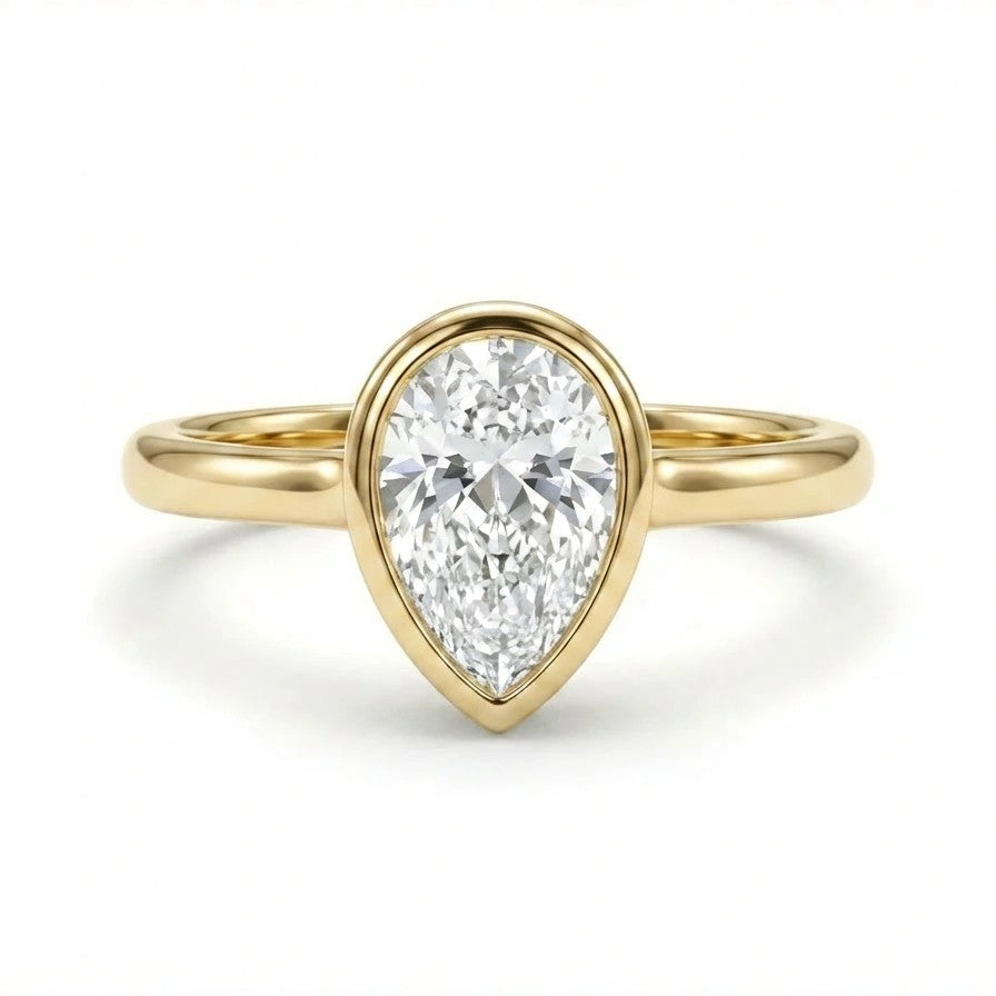 Solid 14K yellow gold pear cut diamond ring with bezel setting and polished slim band