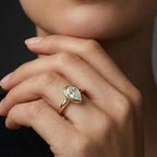 Model wearing pear cut diamond ring in solid gold with bezel setting and elegant minimalist design