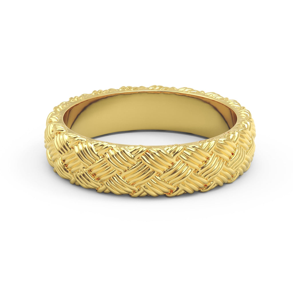 Close-up of woven gold ring with detailed basket weave texture on white surface