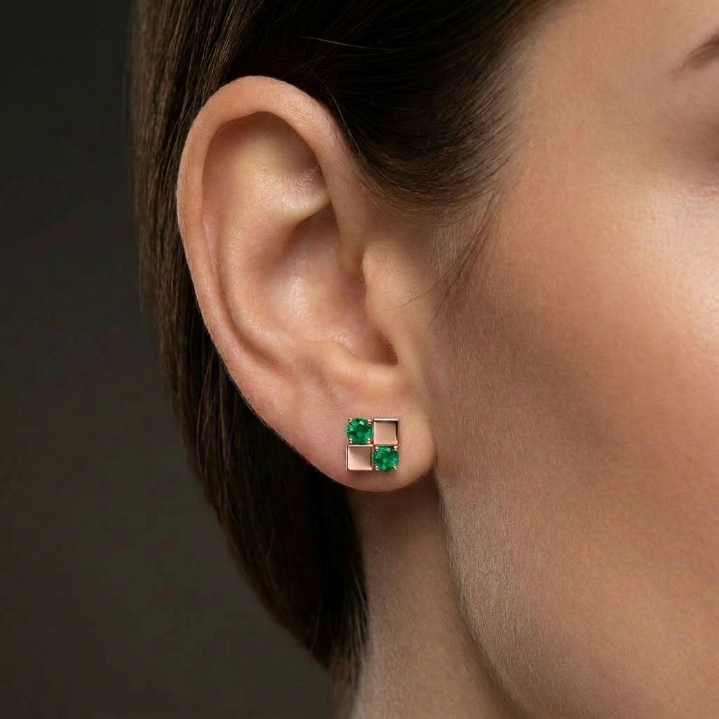 Woman wearing Zyven emerald matrix stud earrings with modern geometric square design and green gemstones